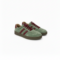 A pair of green suede sneakers with burgundy laces, burgundy side stripes, and a brown sole, shown on a white background.