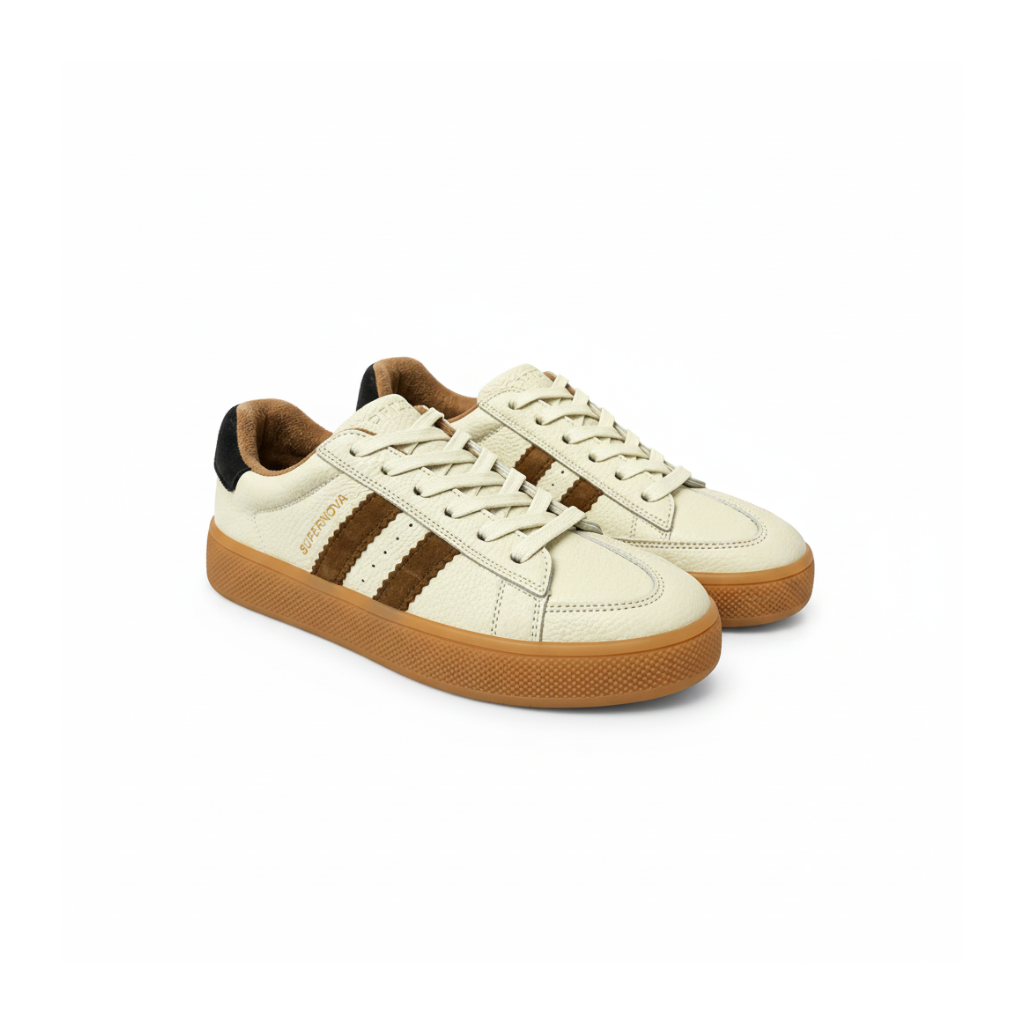 A pair of low-top sneakers in off-white leather with three brown suede stripes, a brown gum sole, and a black heel tab. The word 'SUPERNOVA' is printed in gold on the side of the front shoe.